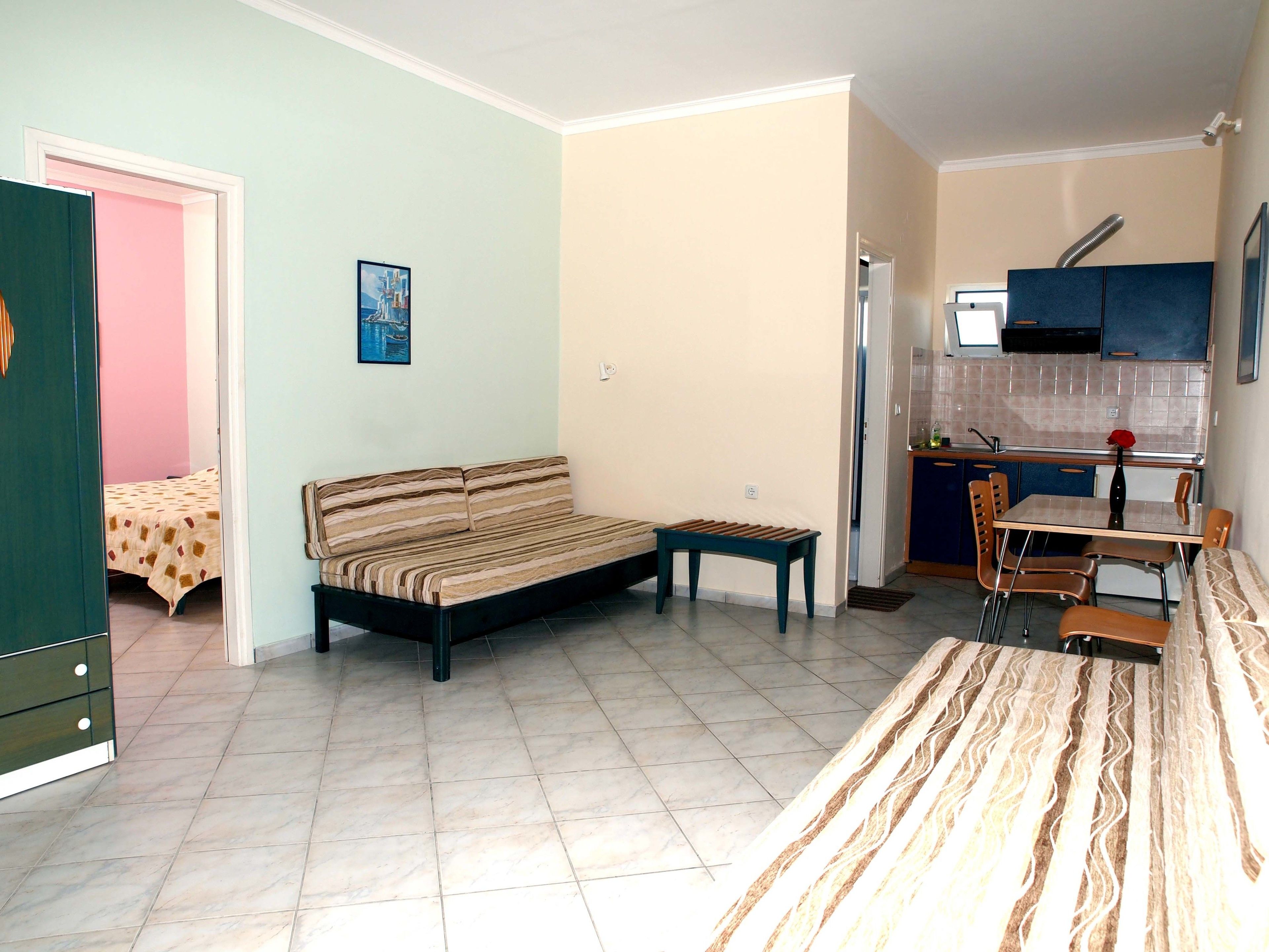 A compact living space with a sofa, a dining table, and a kitchenette.