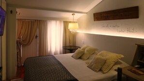 A hotel room with a bed, a lamp, a wall with a sign, and curtains. - Solar das Artes Pousada Boutique (Salvador)