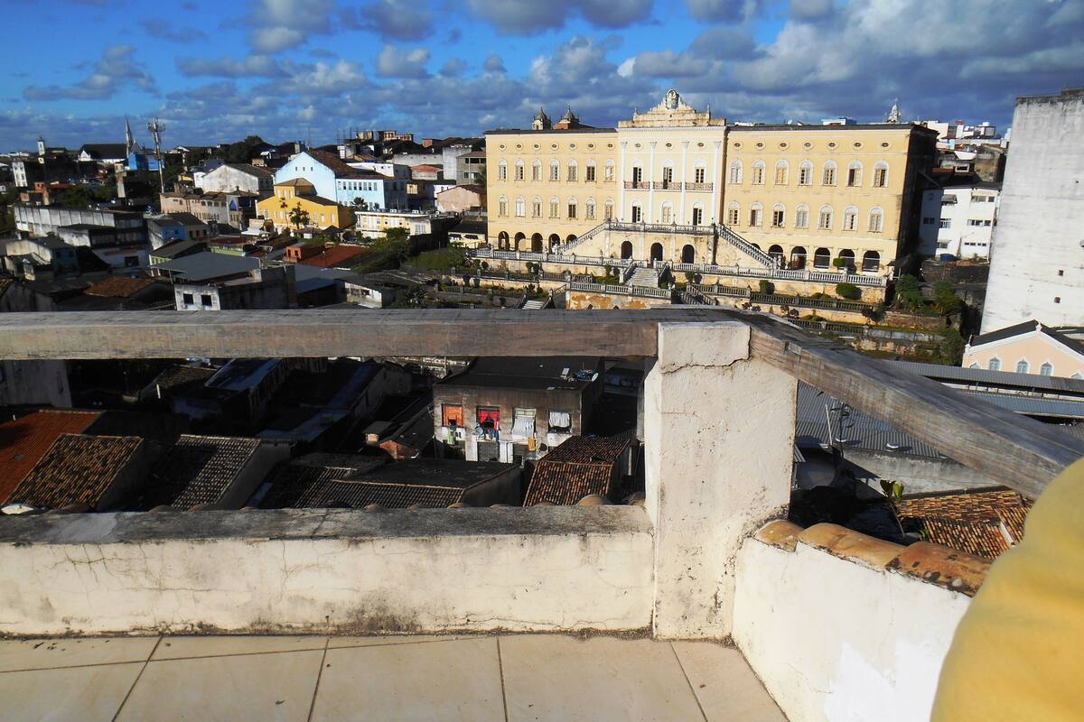 A rooftop terrace with a view of a historic building and surrounding urban area.