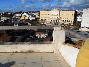 A rooftop terrace with a view of a historic building and surrounding urban area.