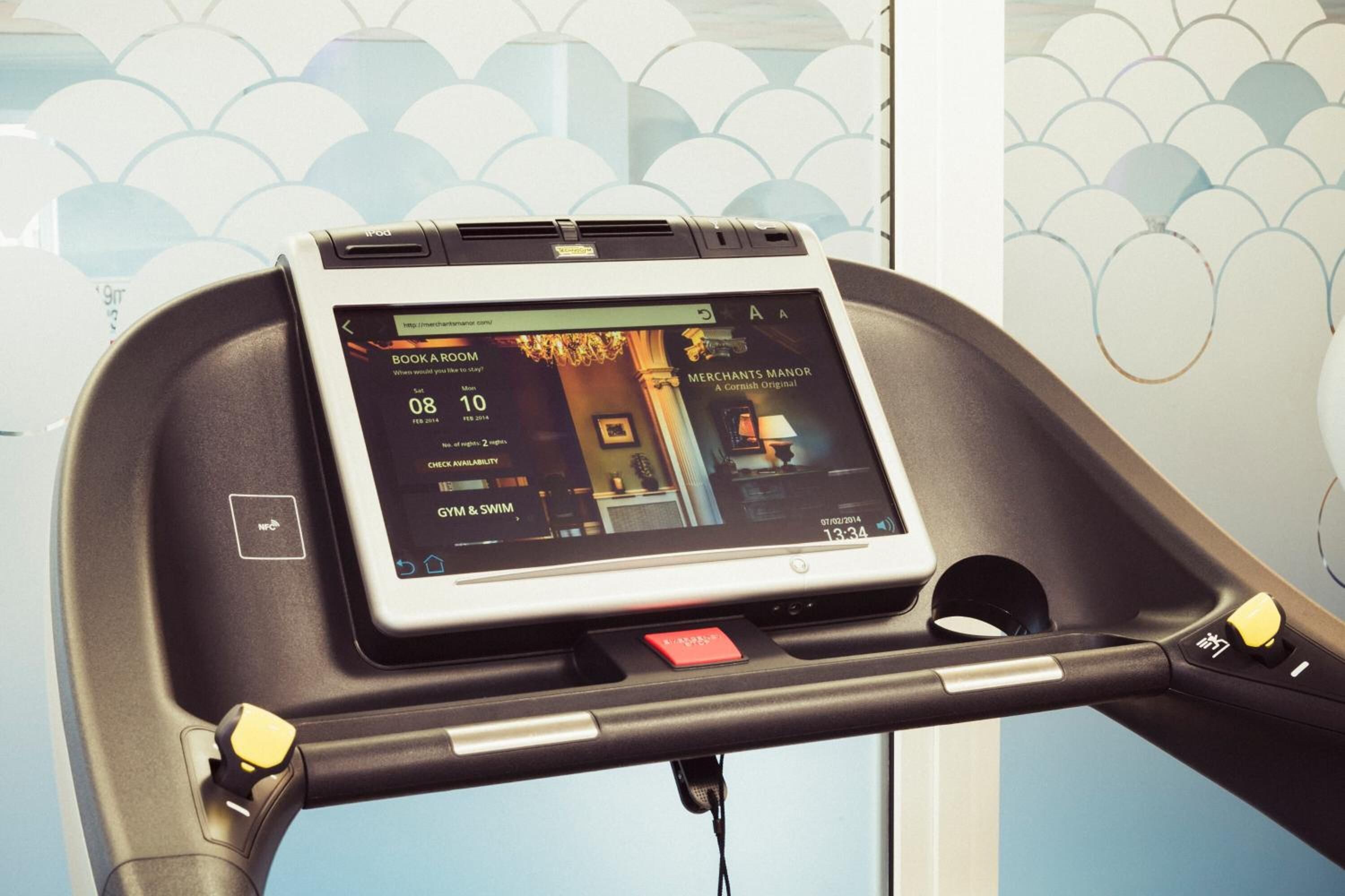 A digital display on a treadmill with a booking interface, indicating a booking for 'Merchants Manor' on 08/10.