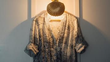 A patterned dress hanging on a wall with a light fixture above it.