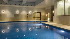 A large indoor swimming pool with a tiled floor and walls, surrounded by a light-colored interior. - Merchants Manor (Falmouth)