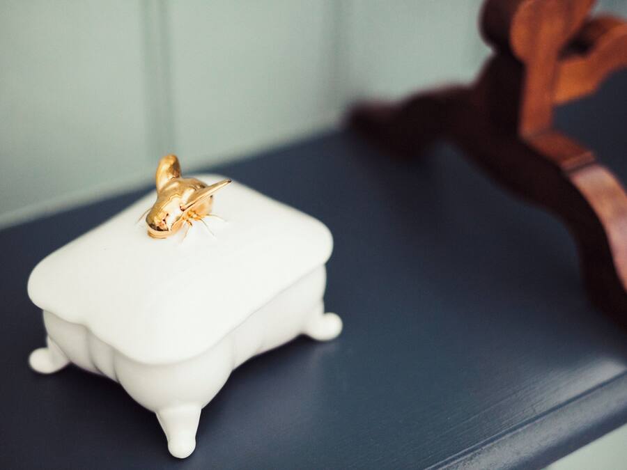 A white, rectangular, vintage-style object with a golden emblem on a dark surface.