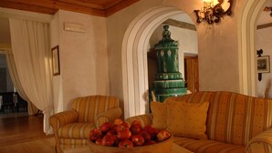 A living room with striped sofas, a wooden coffee table, and a bowl of apples. - Excelsior (Cavalese)