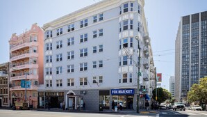 Un edificio de varios pisos con un espacio comercial en la planta baja identificado como "FOX MARKET".