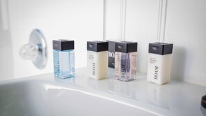 Un estante en el baño con cuatro artículos de tocador ROAM.