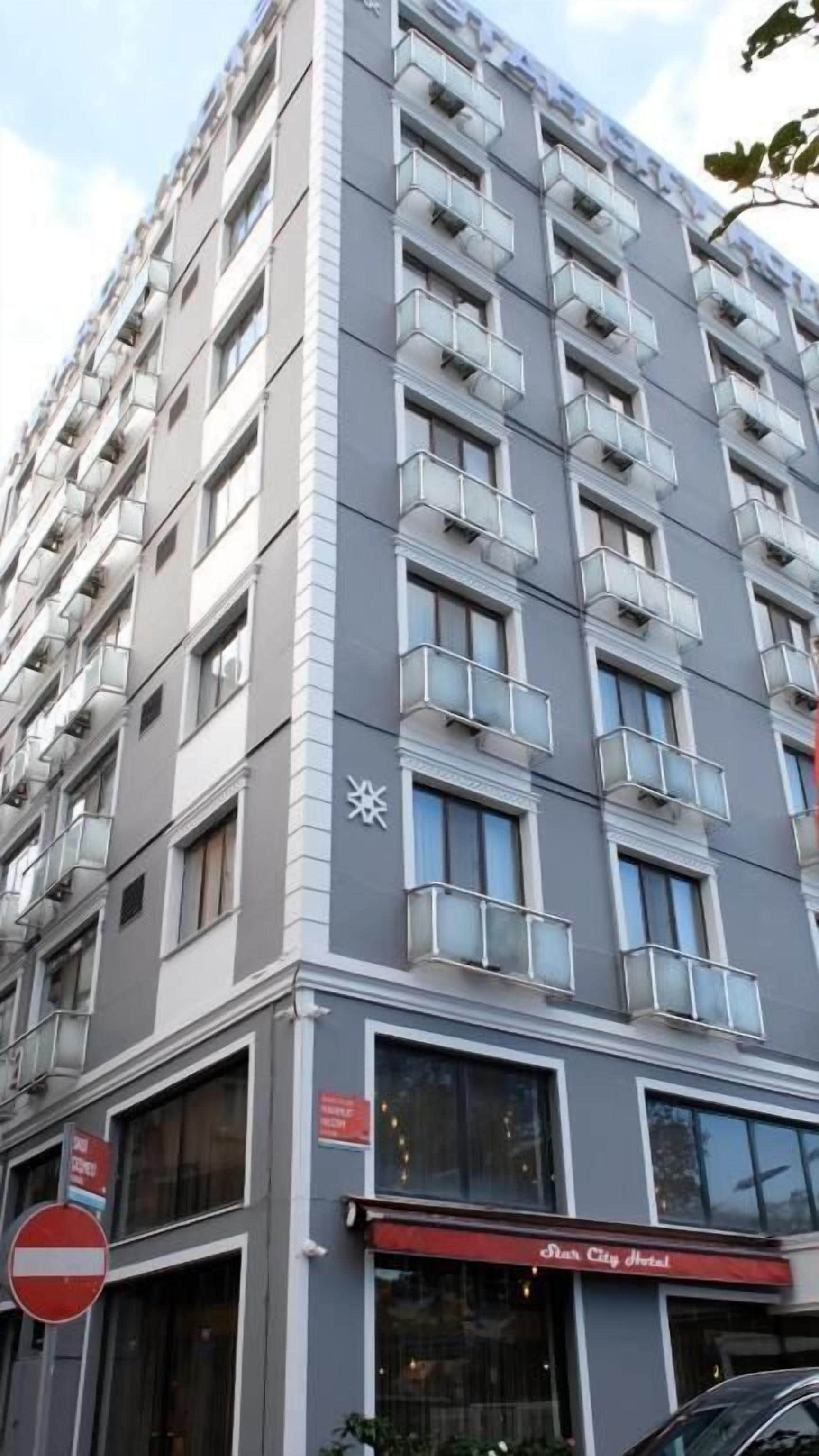 A multi-story hotel with balconies, large windows, and a sign for 'Star City Hotel'.