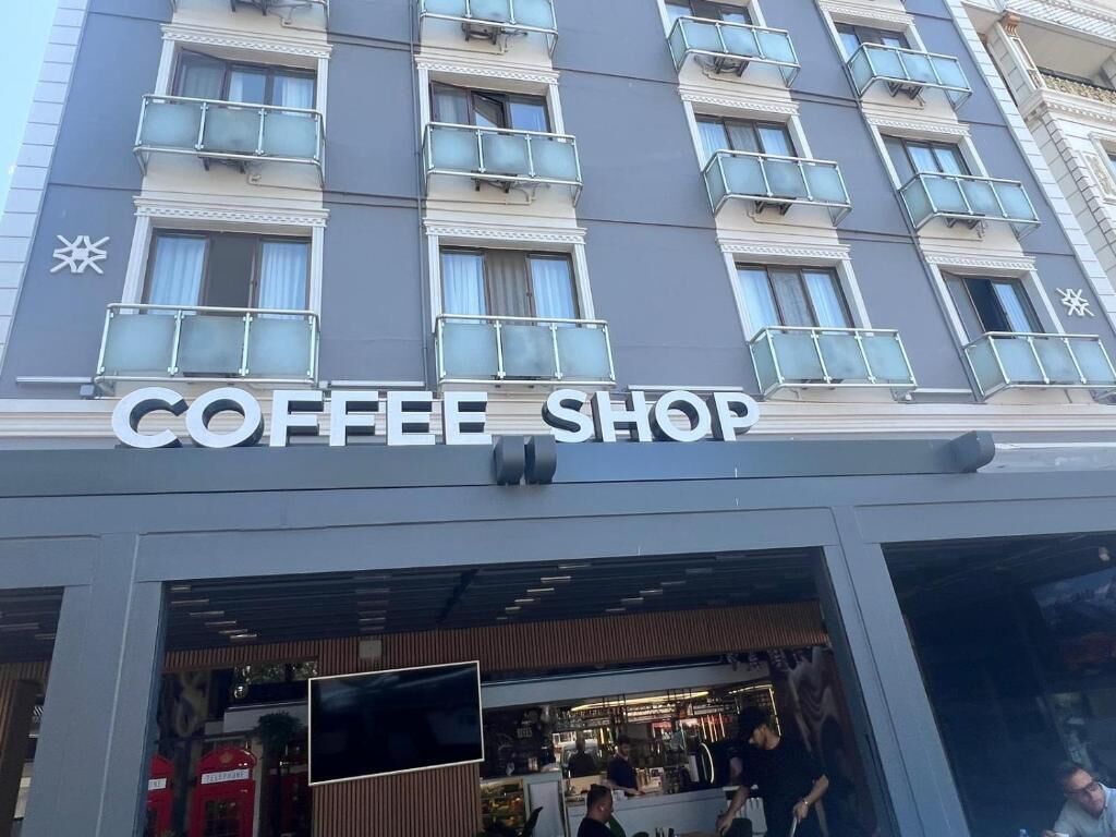 Una cafetería con fachada moderna y un letrero sobre la entrada.