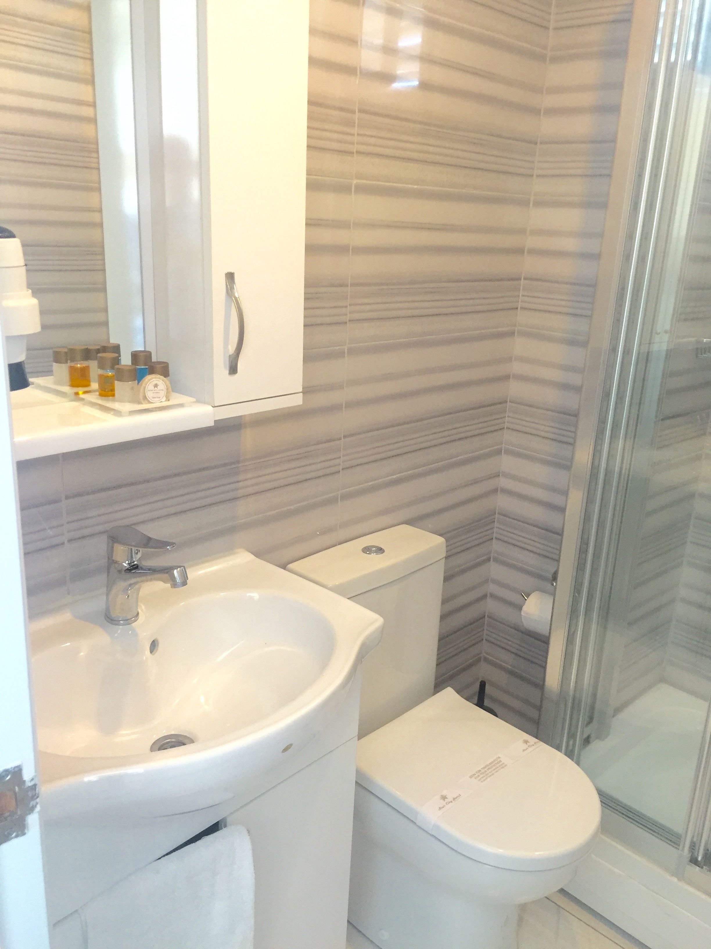 A bathroom with a sink, toilet, and glass shower enclosure.