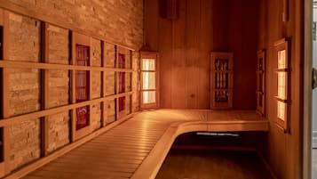 A traditional Japanese onsen with wooden floors, tiled walls, and wooden sliding doors with red accents.