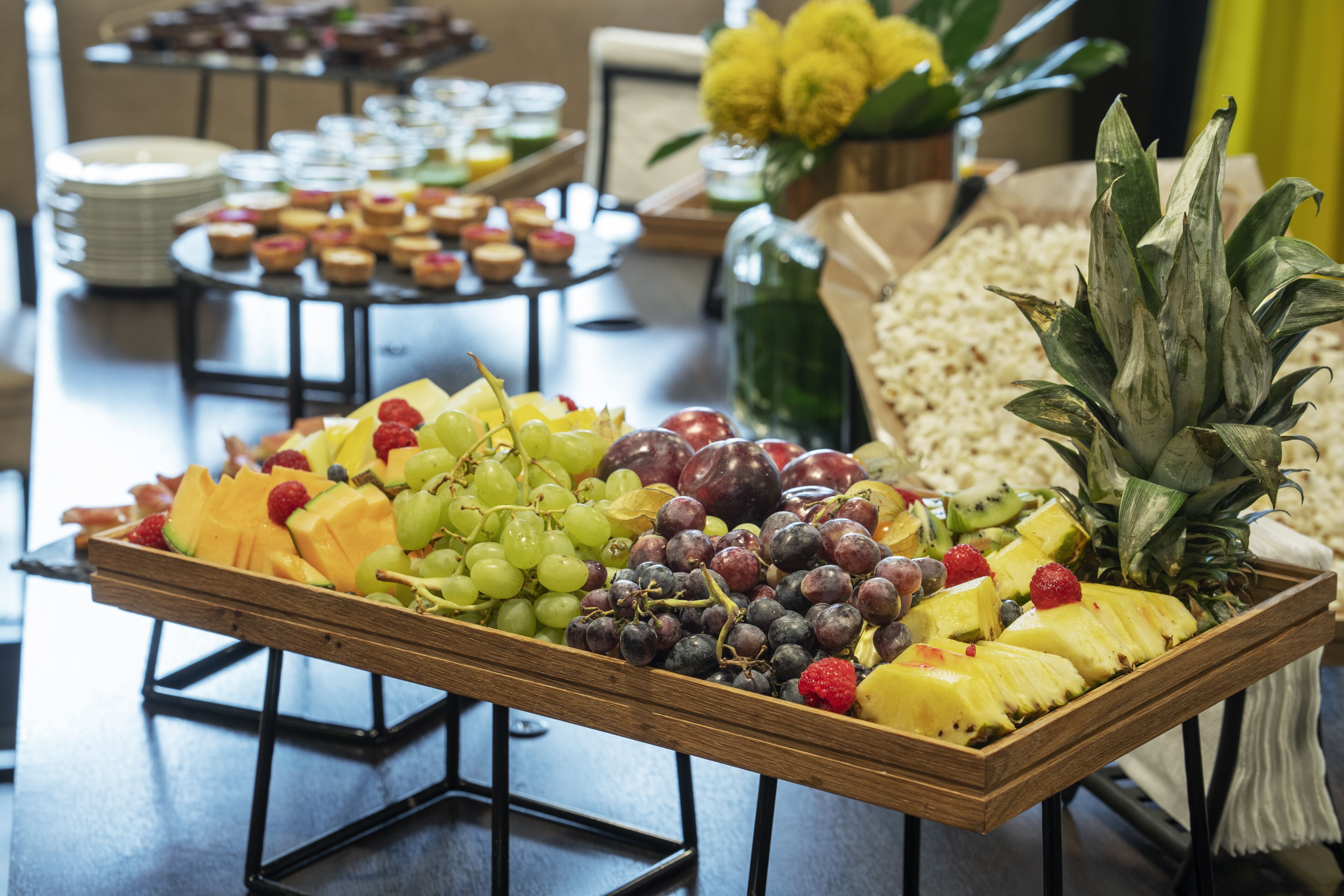 A buffet table with a variety of fruits and pastries.