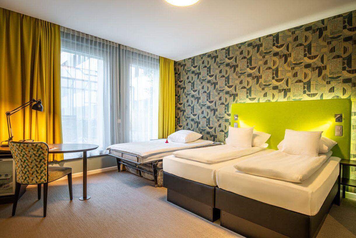 Una habitación de hotel con dos camas, un escritorio y una silla.