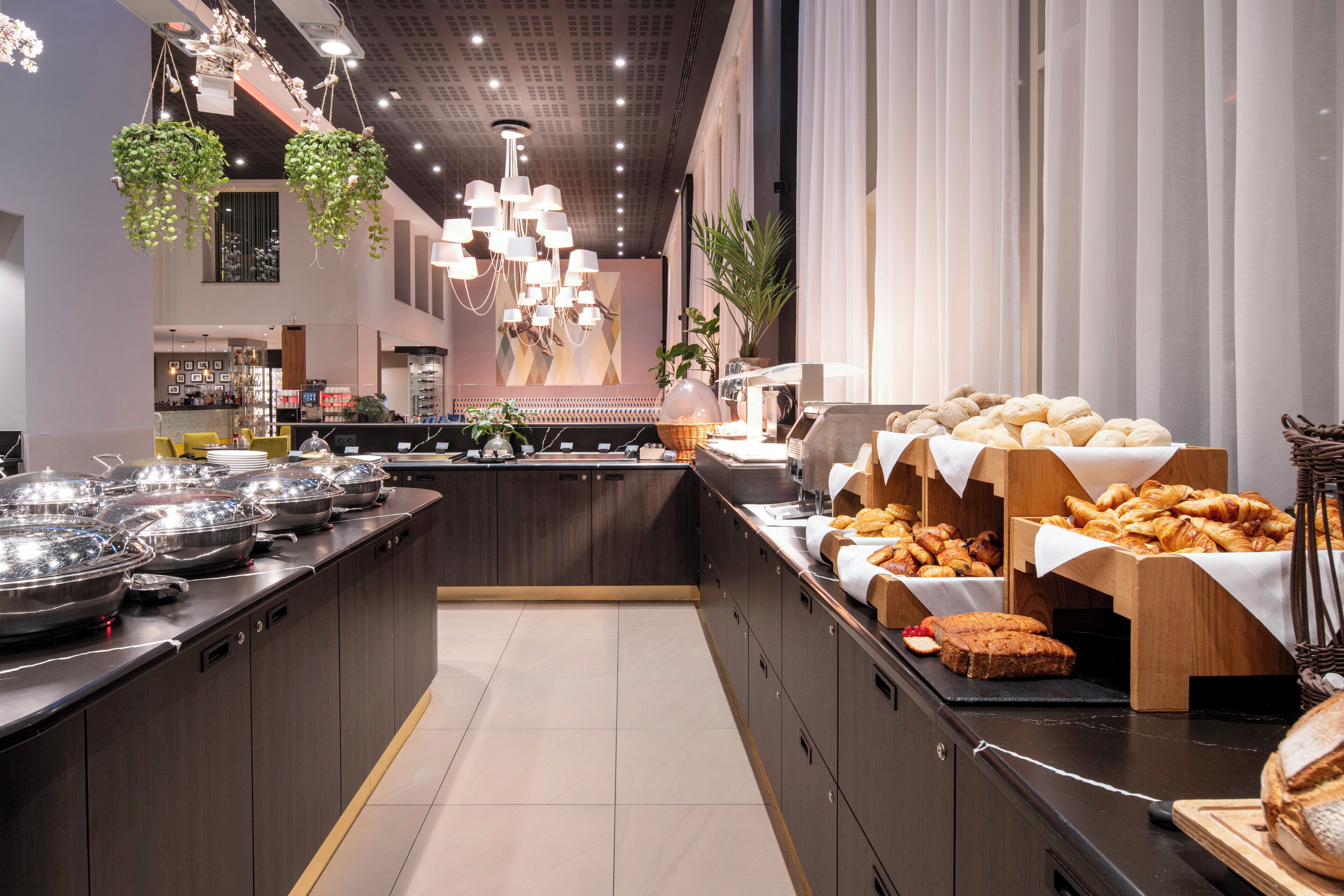 A buffet area with various food items and a bar in the background.