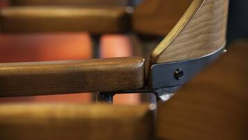 A row of wooden chairs with metal frames, arranged in a row.