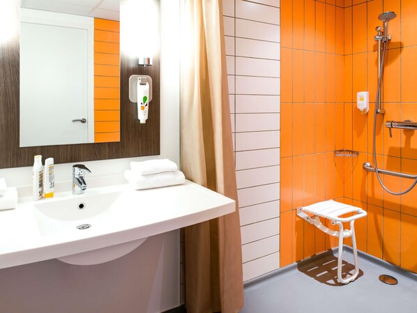 A bathroom with a white sink, mirror, and shower. - ibis Styles Lyon Centre - Gare Part Dieu Hotel (Lyon)