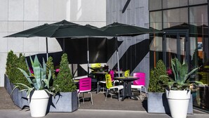 A modern building with the sign "ibis styles" above the entrance. There are outdoor seating areas with umbrellas and potted plants. - ibis Styles Lyon Centre - Gare Part Dieu Hotel (Lyon)