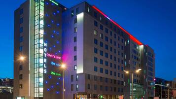 A multi-story hotel with illuminated signage for 'Mercure' and 'Ibis Styles' brands.
