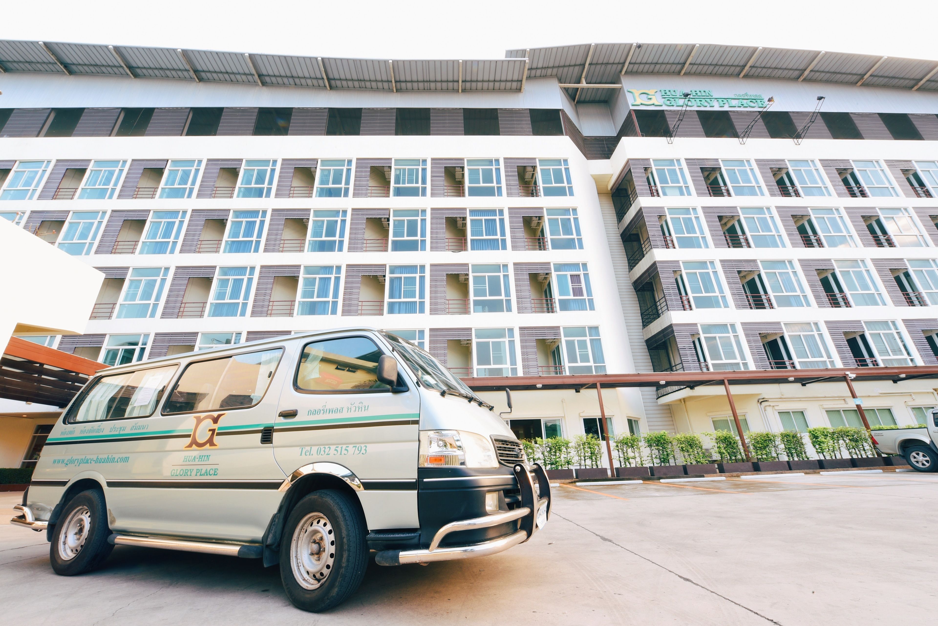 A van parked in front of a multi-story building with a sign that reads "GLORY PLACE".