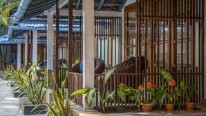 A covered outdoor area with potted plants and a wooden fence. - Casa Vagator (Vagator)