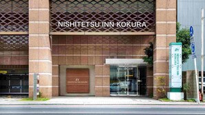 L’extérieur de l’hôtel Nishi-Tetsu Inn Kokura, avec son entrée bien visible et son panneau indicateur.