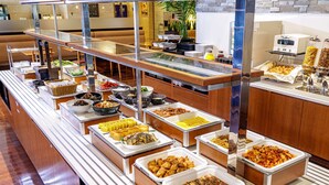 A buffet with various food options, a coffee machine, and a plant in the background. - Nishitetsu Inn Kurosaki (Kitakyushu)