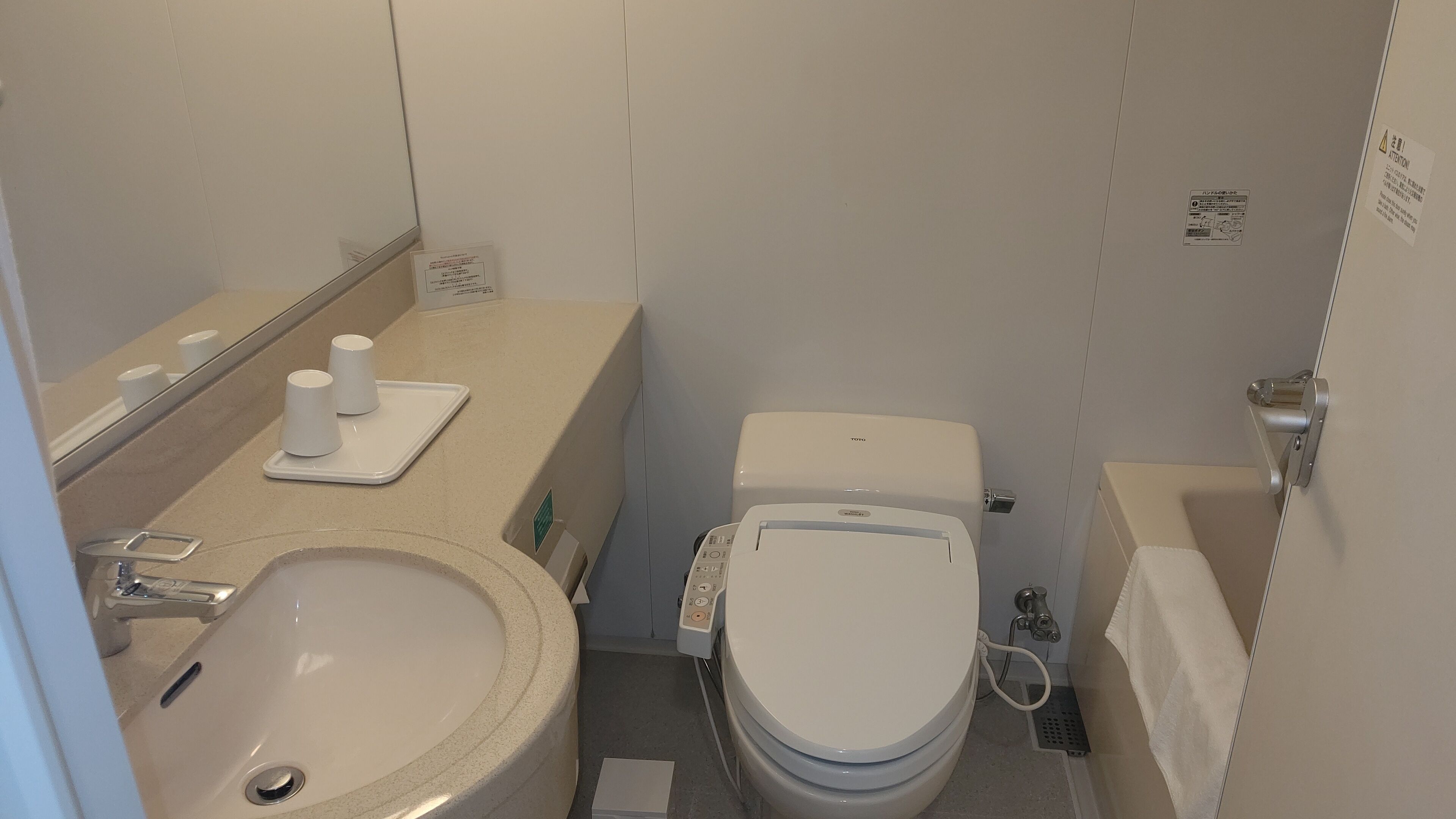 Une petite salle de bain comprenant un lavabo, des toilettes et un petit miroir.