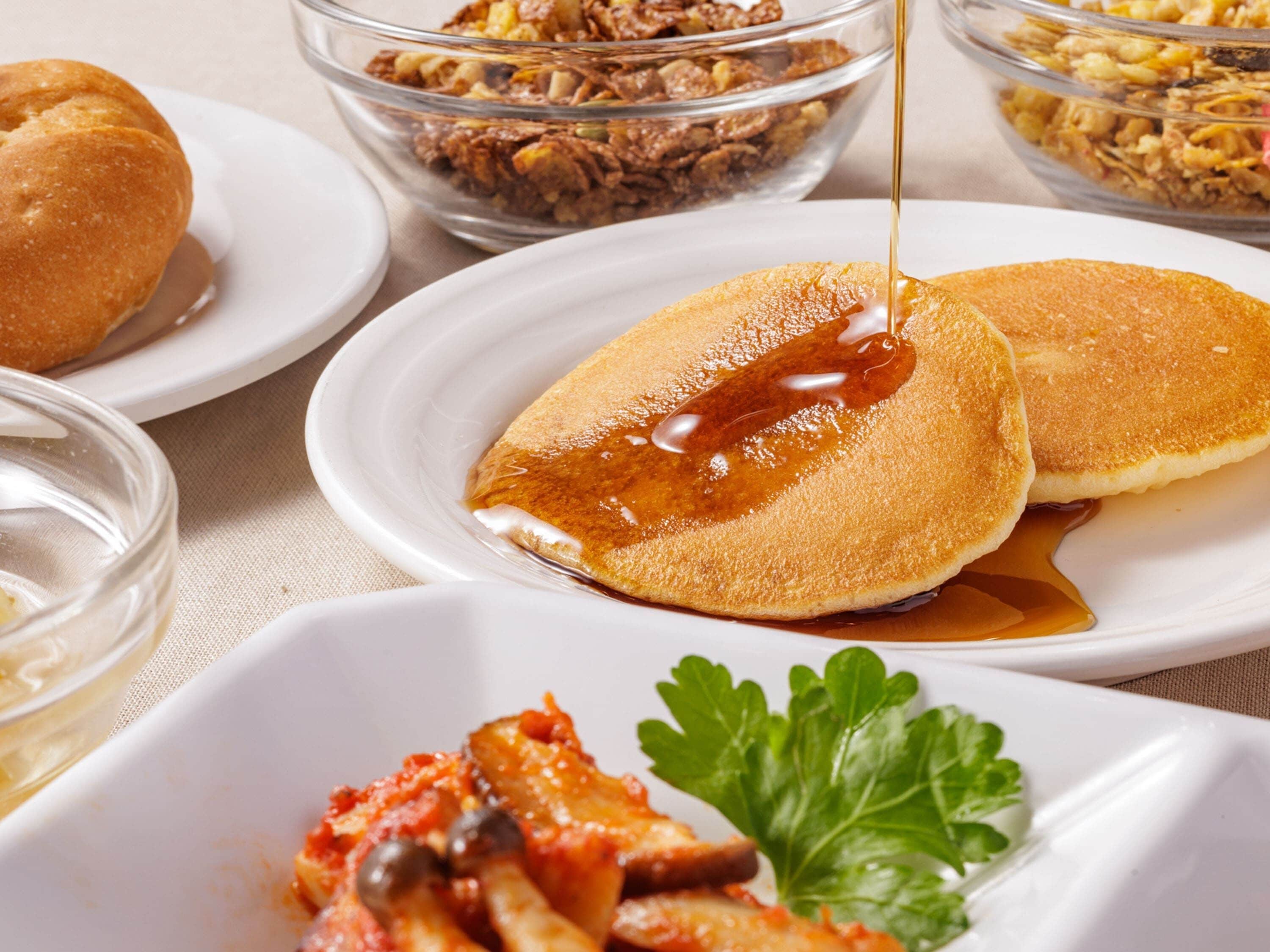 Desayuno con tortitas, almíbar y un acompañamiento.