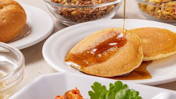 Desayuno con tortitas, almíbar y un acompañamiento.