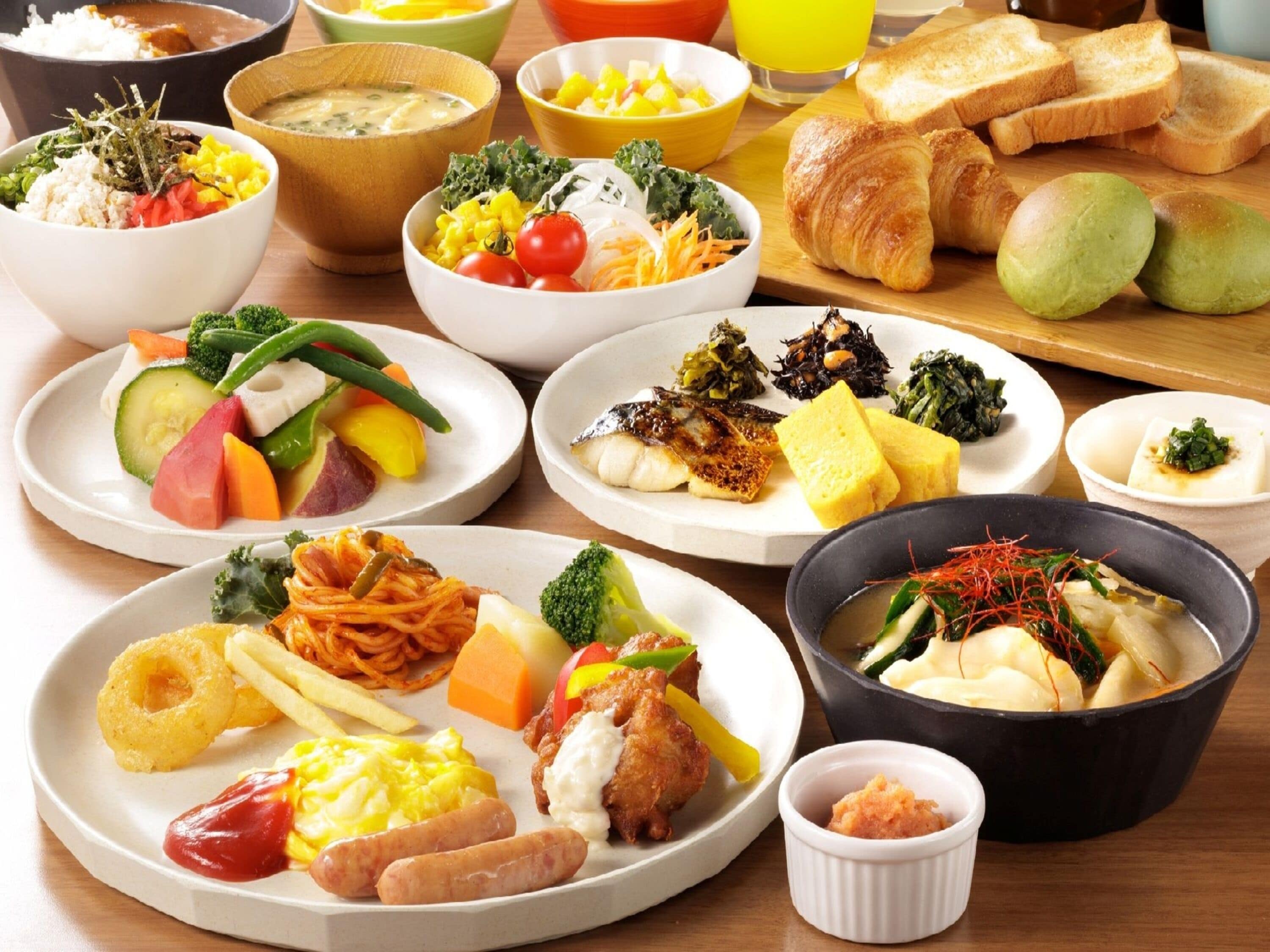 Variedad de platos que incluyen sushi, verduras y pan.