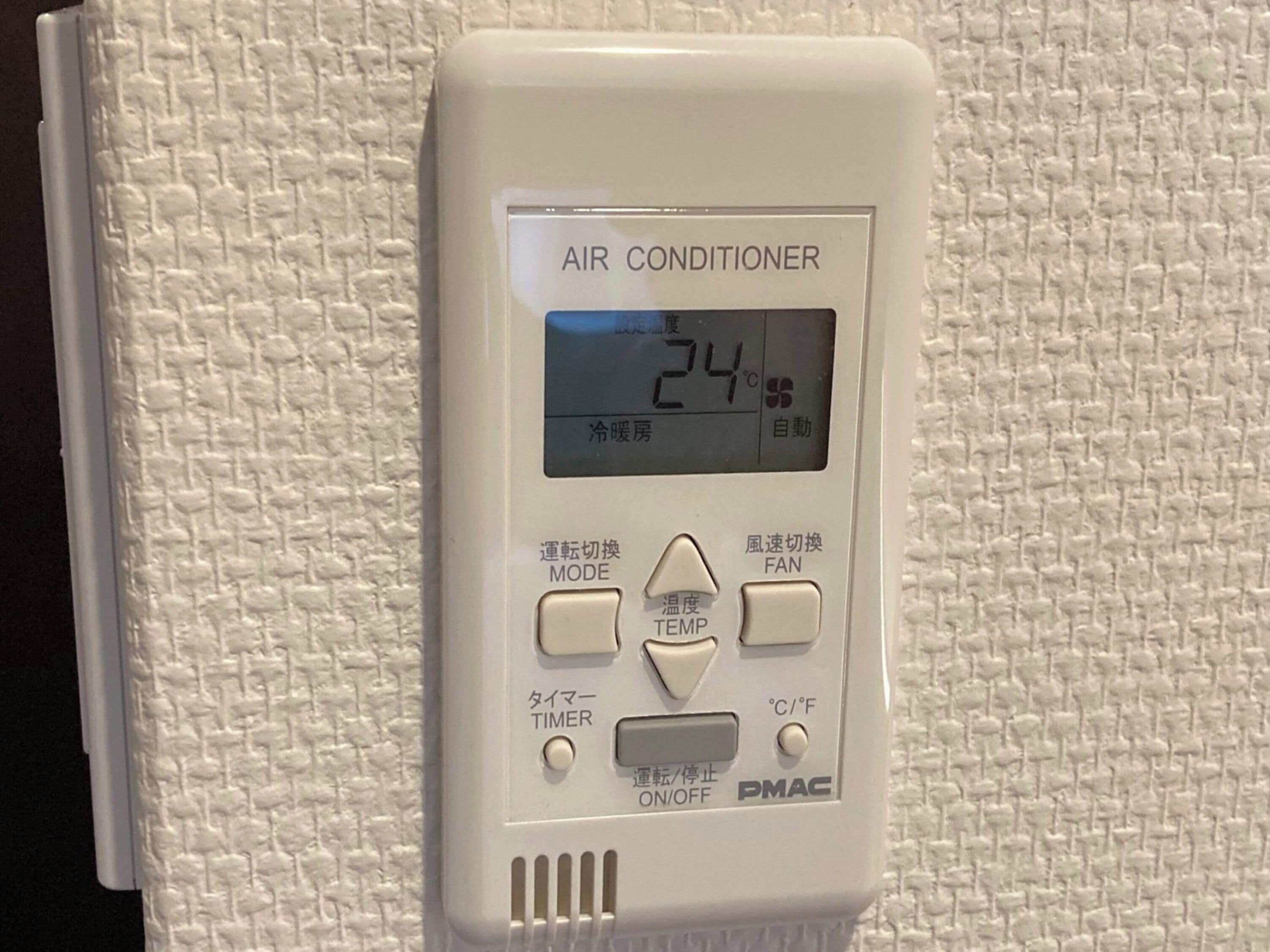 An air conditioner unit with a digital display, mode switch, temperature adjustment, fan speed control, timer, and power switch.