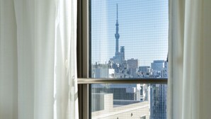 A window with a view of a cityscape, including a prominent tower. - Nishitetsu Inn Nihonbashi (Tokyo)