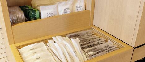 Un cajón de madera con artículos de aseo personal ordenados, como maquinillas y gel de baño.
