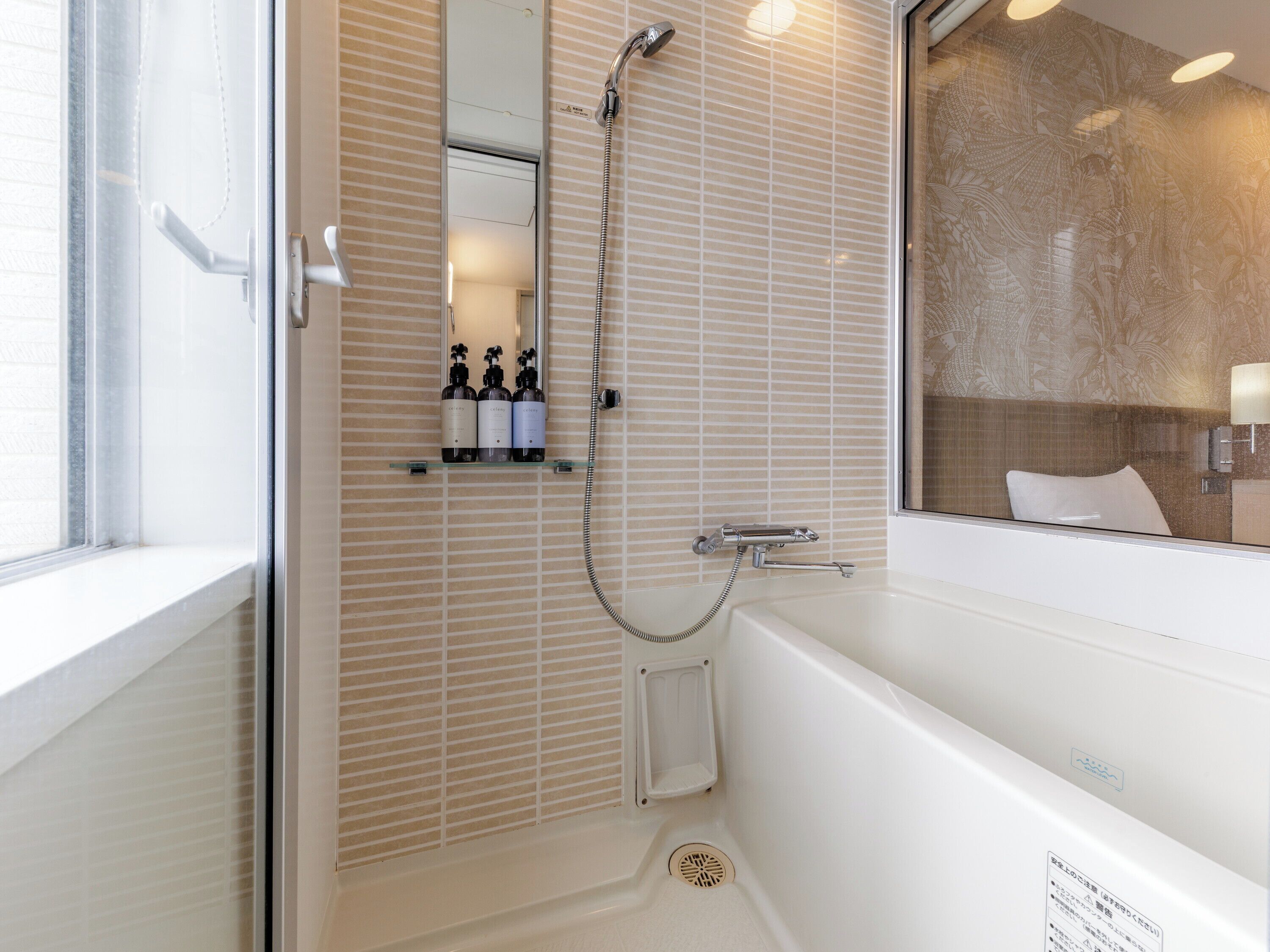 Une salle de bain moderne équipée d’une baignoire, d’une douche et d’un meuble-lavabo avec des articles de toilette.