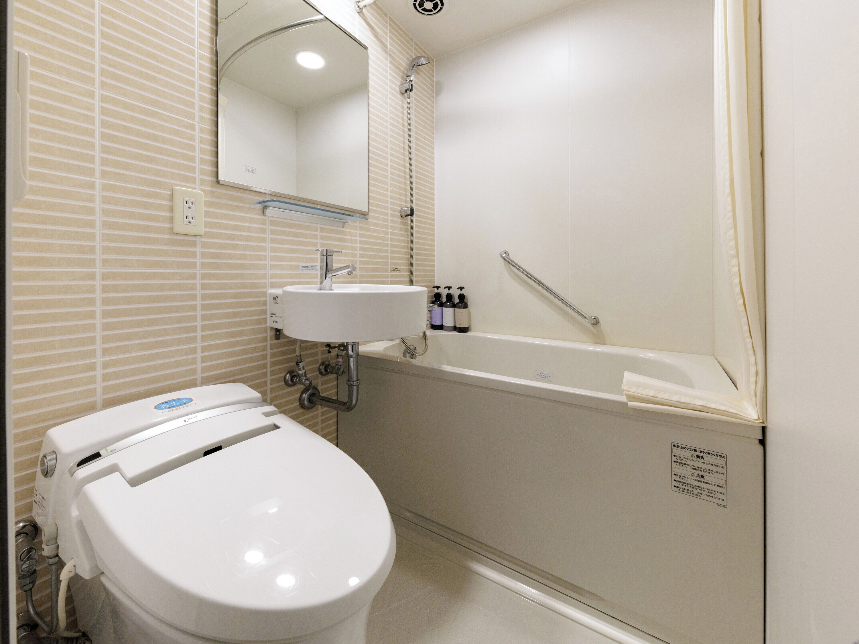 Un baño con inodoro, lavamanos y ducha.