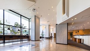 A spacious lobby with a high ceiling, large windows, and a reception desk. - Nishitetsu Inn Fukuoka (Fukuoka)