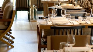 A restaurant interior with tables set for dining, chairs, and a decorative wall. - Solaria Nishitetsu Hotel Ginza (Tokyo)