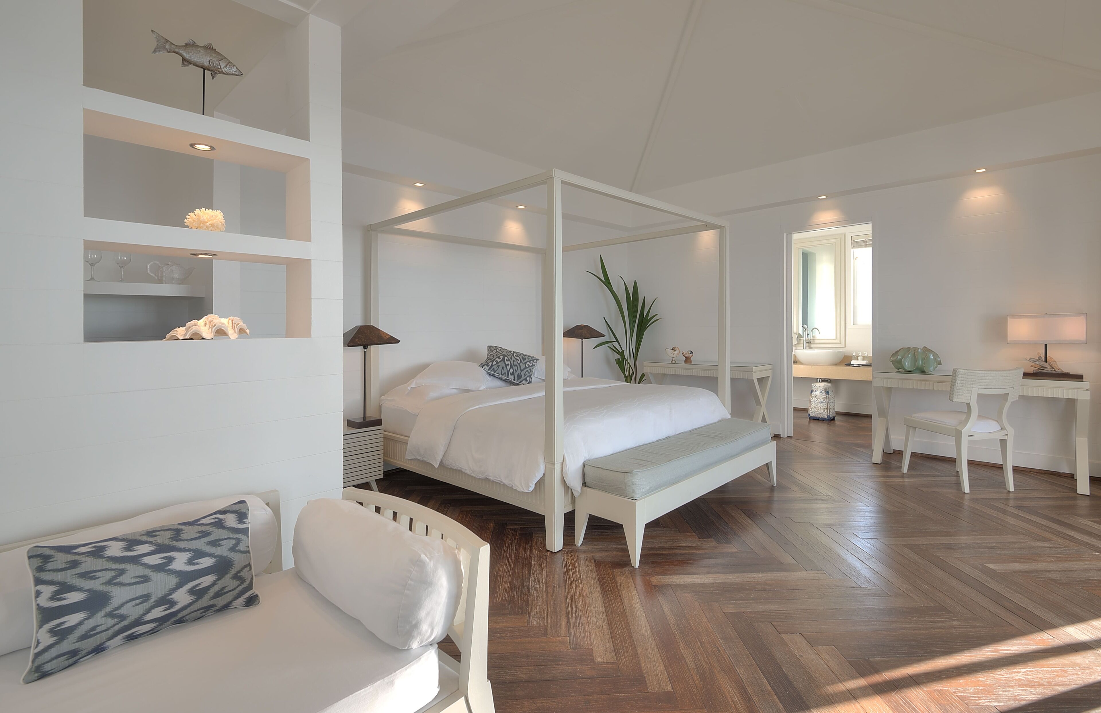 Une chambre spacieuse avec un lit à baldaquin, une table de chevet, une chaise, un bureau et un miroir.