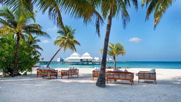 Praia particular, areia branca, espreguiçadeiras, guarda-sóis