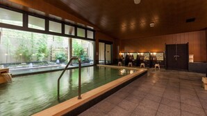 Une piscine dotée d’une terrasse en bois et offrant une vue sur la verdure environnante.