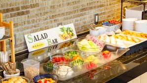 Un buffet proposant divers plats et une pancarte indiquant la présence d’un bar à salades.