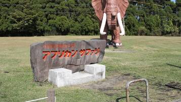 A large elephant statue with a stone base and a sign in front of it.