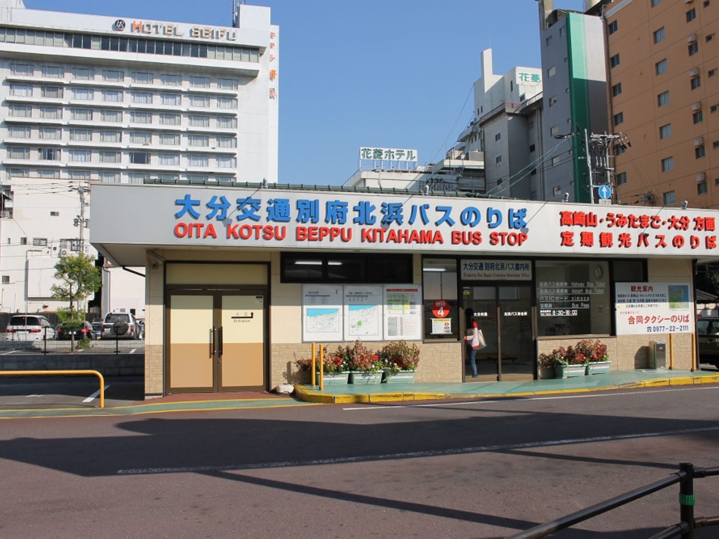 A bus stop with a sign in Japanese and English, indicating it is the Oita Kotsu Beppu Kitahama Bus Stop.