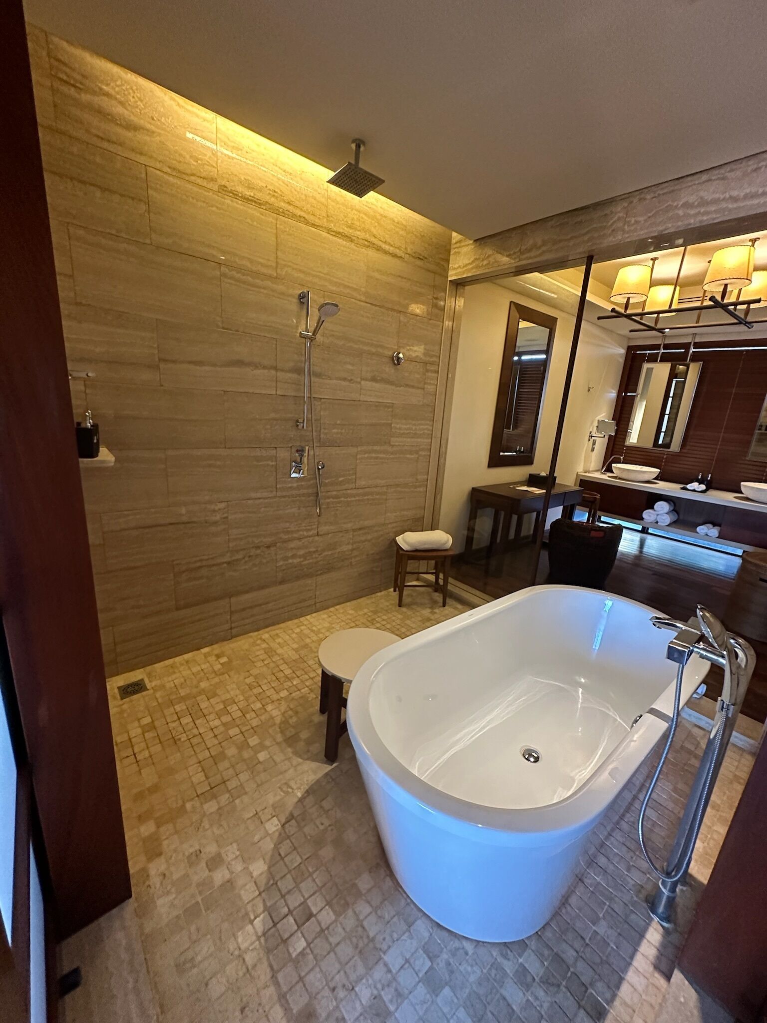 Un baño moderno con una bañera independiente, zona de ducha y tocador con espejo.