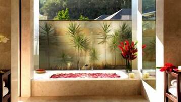 Bathroom with a garden view, featuring a bathtub and potted plants.