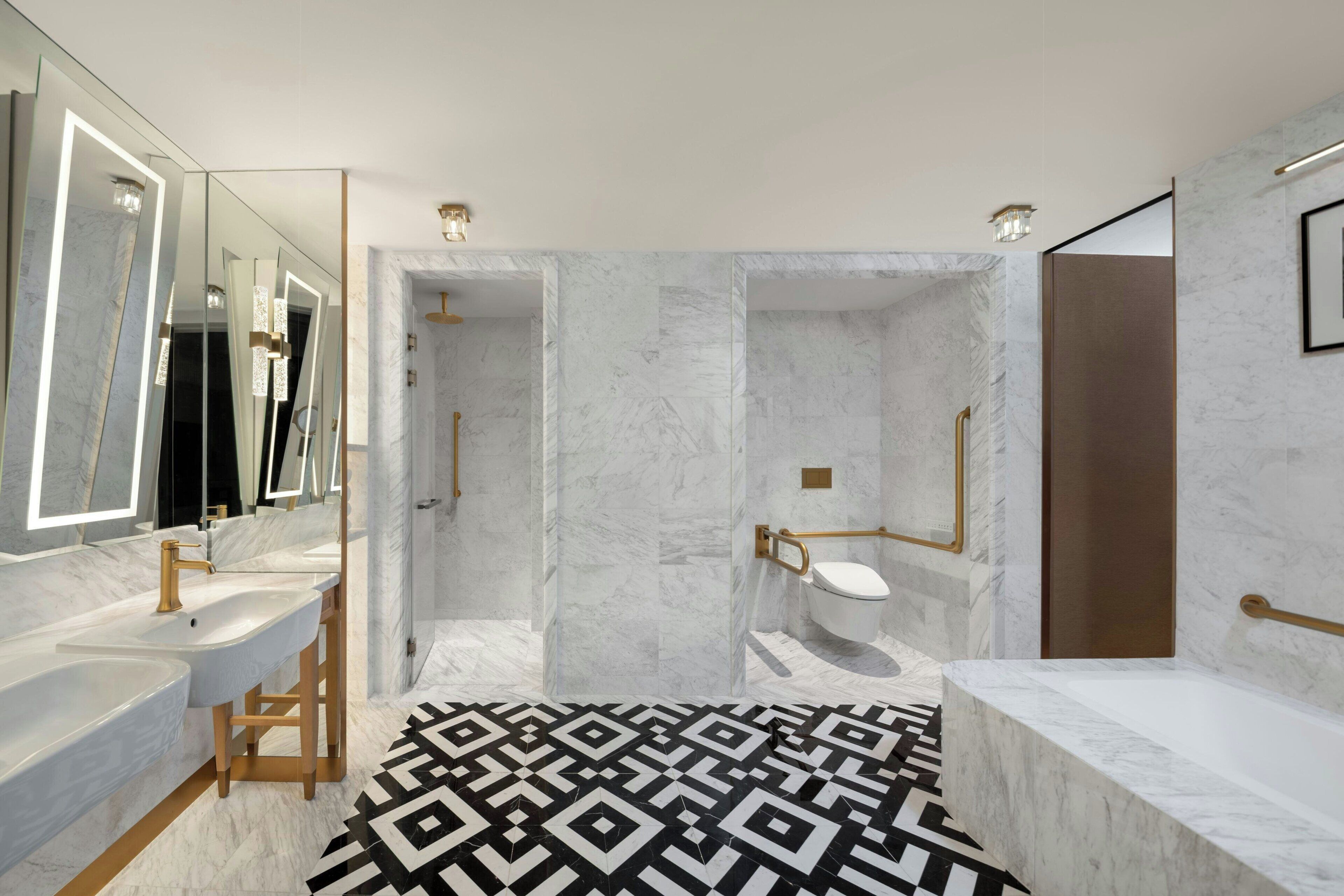 A modern bathroom with a marble floor, dual sinks, and a shower area.