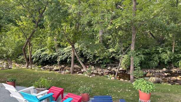 An outdoor seating area with Adirondack chairs and potted plants. - Cozy Corner Motel (Williamstown)