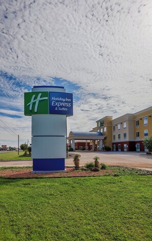 A Holiday Inn Express & Suites sign with a clear view of the hotel building in the background.