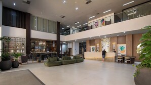 A spacious lobby with a reception desk, seating area, and a bar. - Hotel Gran Odara (Cuiabá)