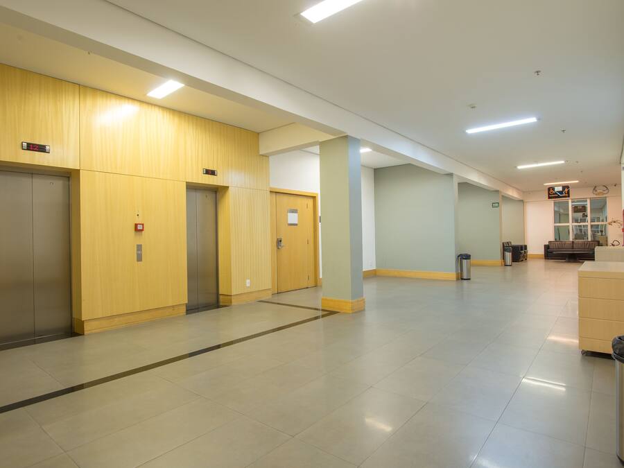 A clean, modern hallway with elevators and a trash bin.